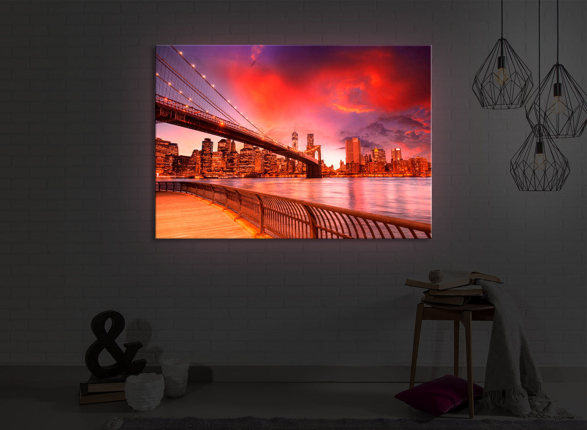 leuchtbild mit dem Motiv Brooklyn Bridge Park New York in einem dunklen Raum. Das Bild leuchtet rot im abgedunkelten Zimmer