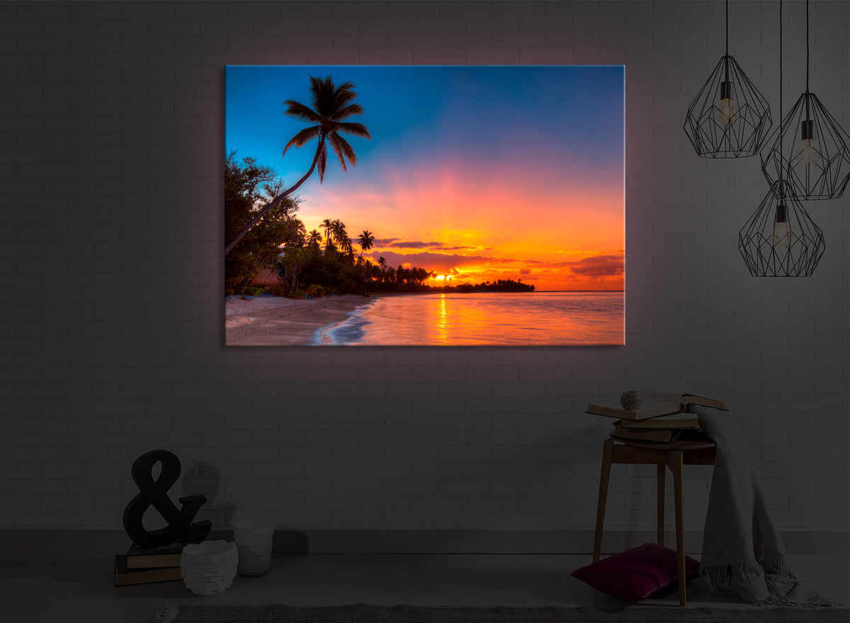 leuchtbild mit dem Motiv Palmen am Strand in einem dunklen Raum. Das Bild leuchtet rot im abgedunkelten Zimmer