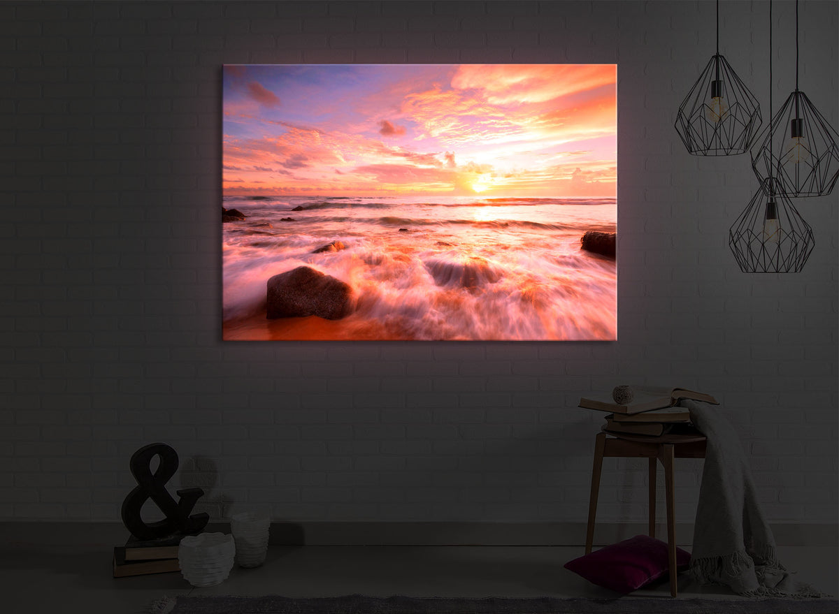leuchtbild mit dem Motiv Sonnenuntergang am Meer in einem dunklen Raum. Das Bild leuchtet rot im abgedunkelten Zimmer