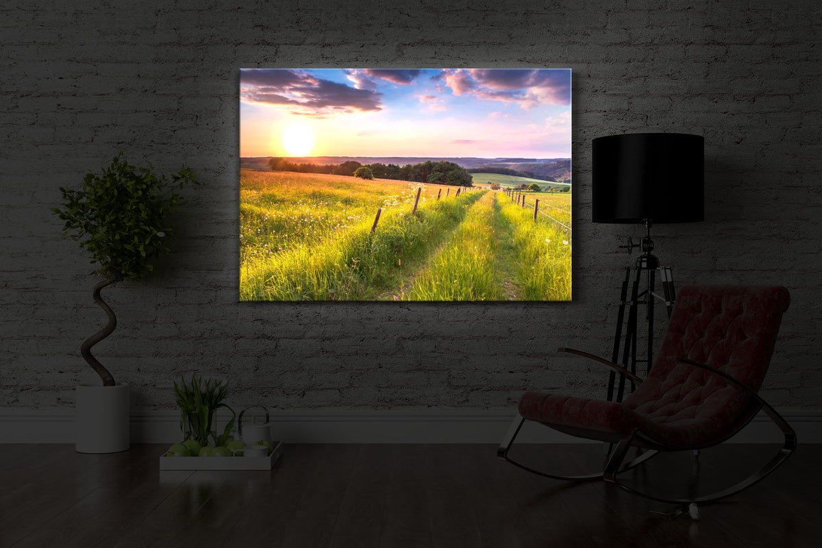 led bild mit dem Motiv Wunderschöne Bergwiese im Sonnenaufgang in einem dunklen Raum. Das Bild leuchtet weiß im abgedunkelten Zimmer